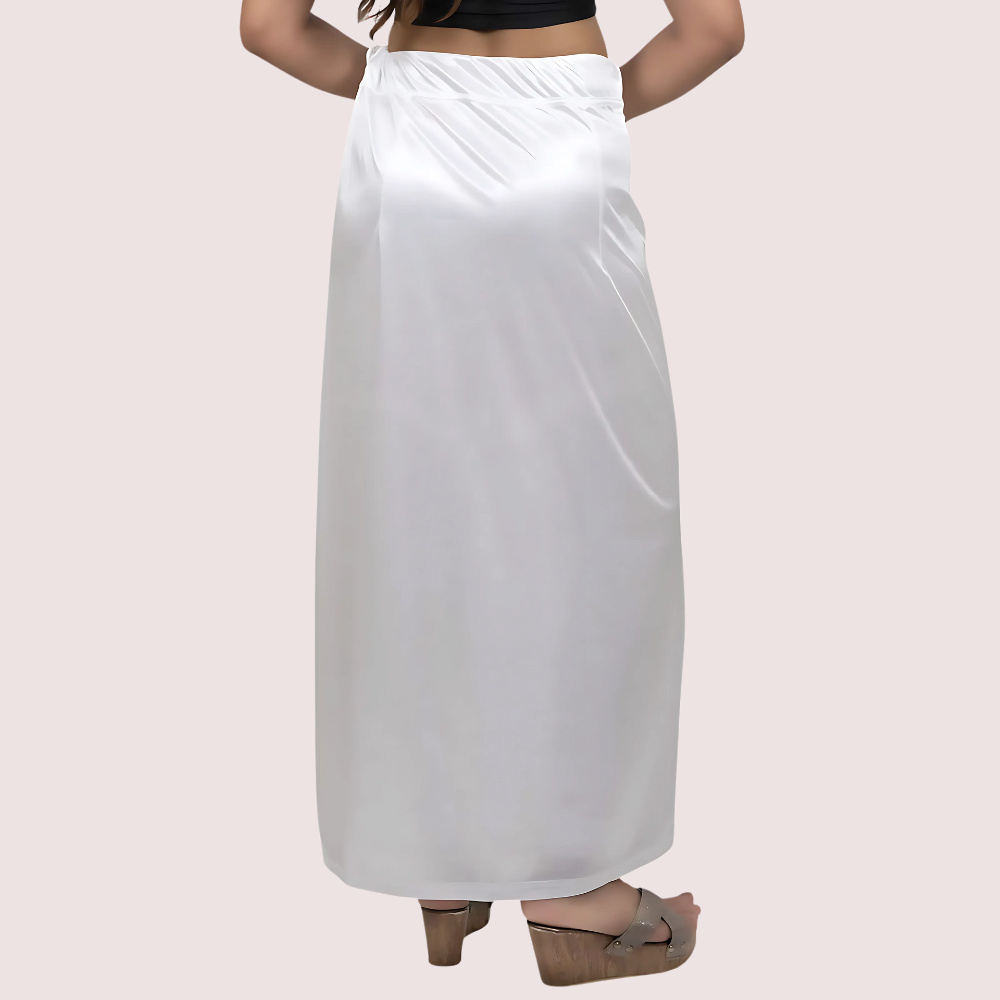 White satin skirt worn by a person on a light pink background