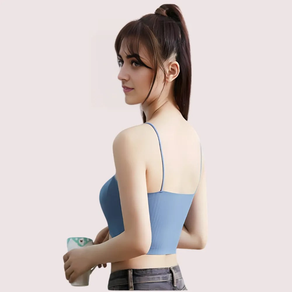 Woman wearing a blue strapless top against a light pink background