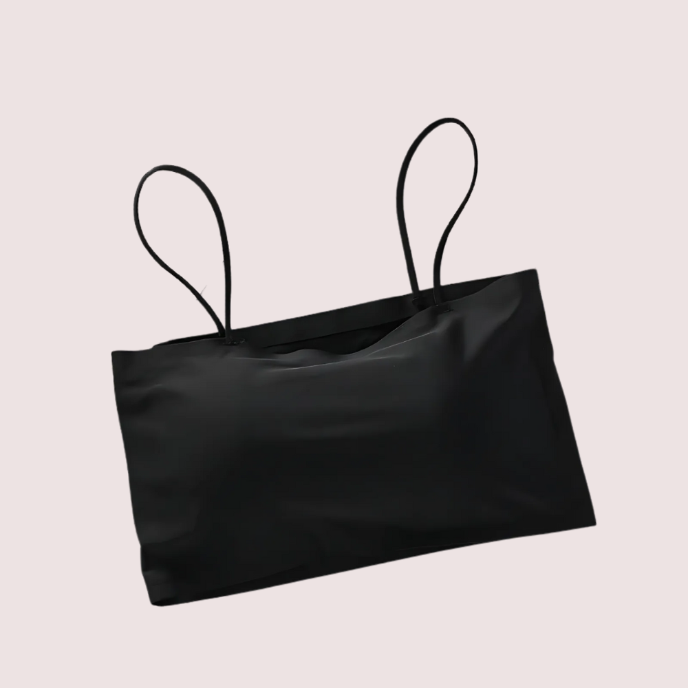 Black satin bag with thin straps on a light beige background