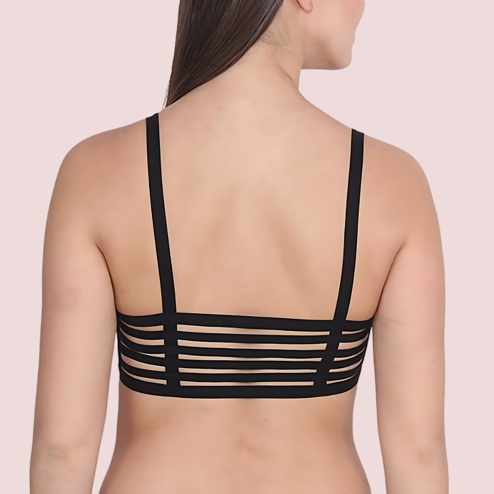 Black strappy top worn by a person on a light pink background