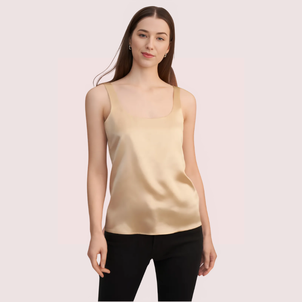 Woman wearing a beige tank top against a light pink background