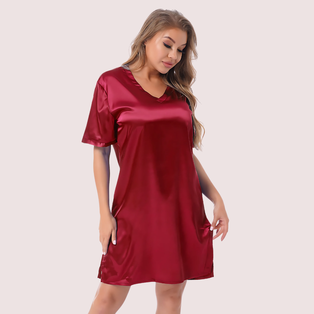 Woman wearing a red satin nightshirt on a plain background