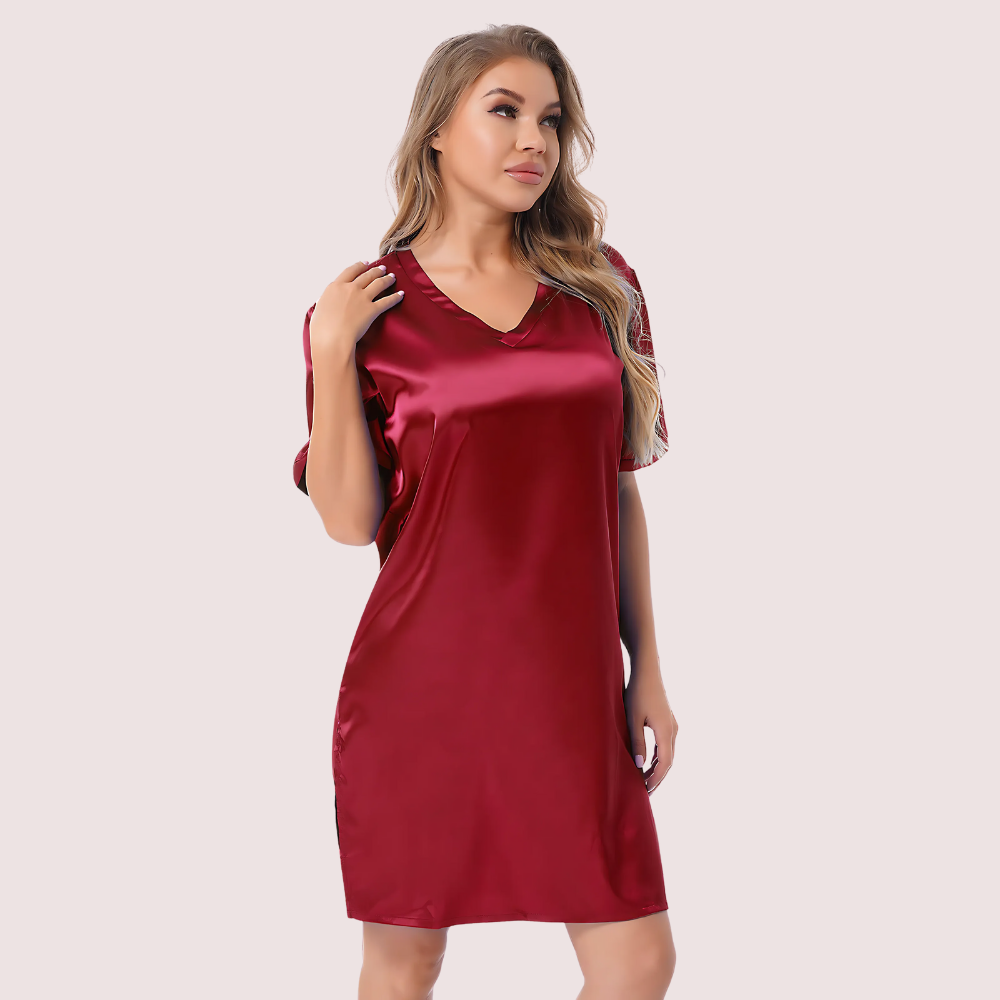 Woman wearing a red satin nightgown against a plain background