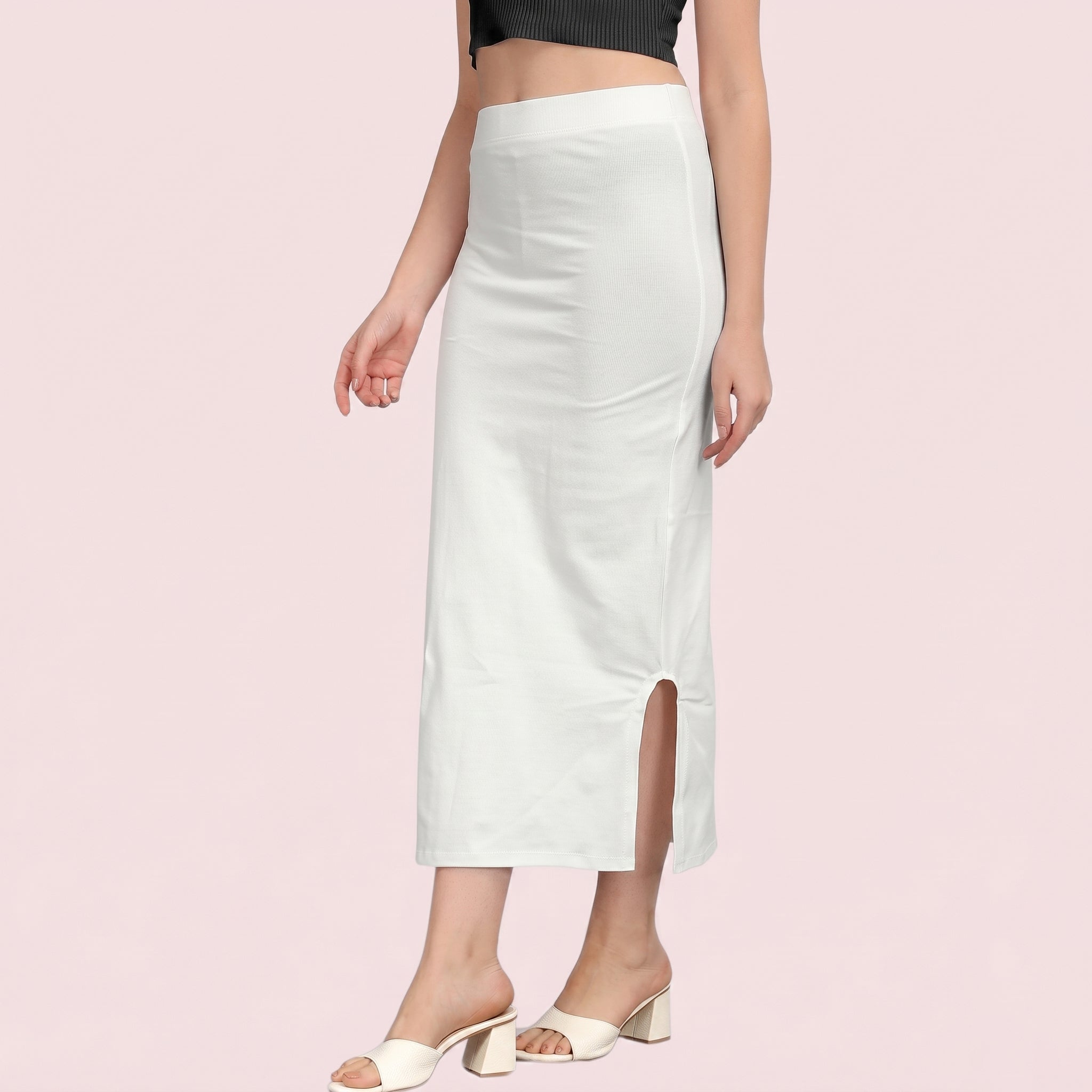 White skirt with a side slit worn by a person on a light pink background