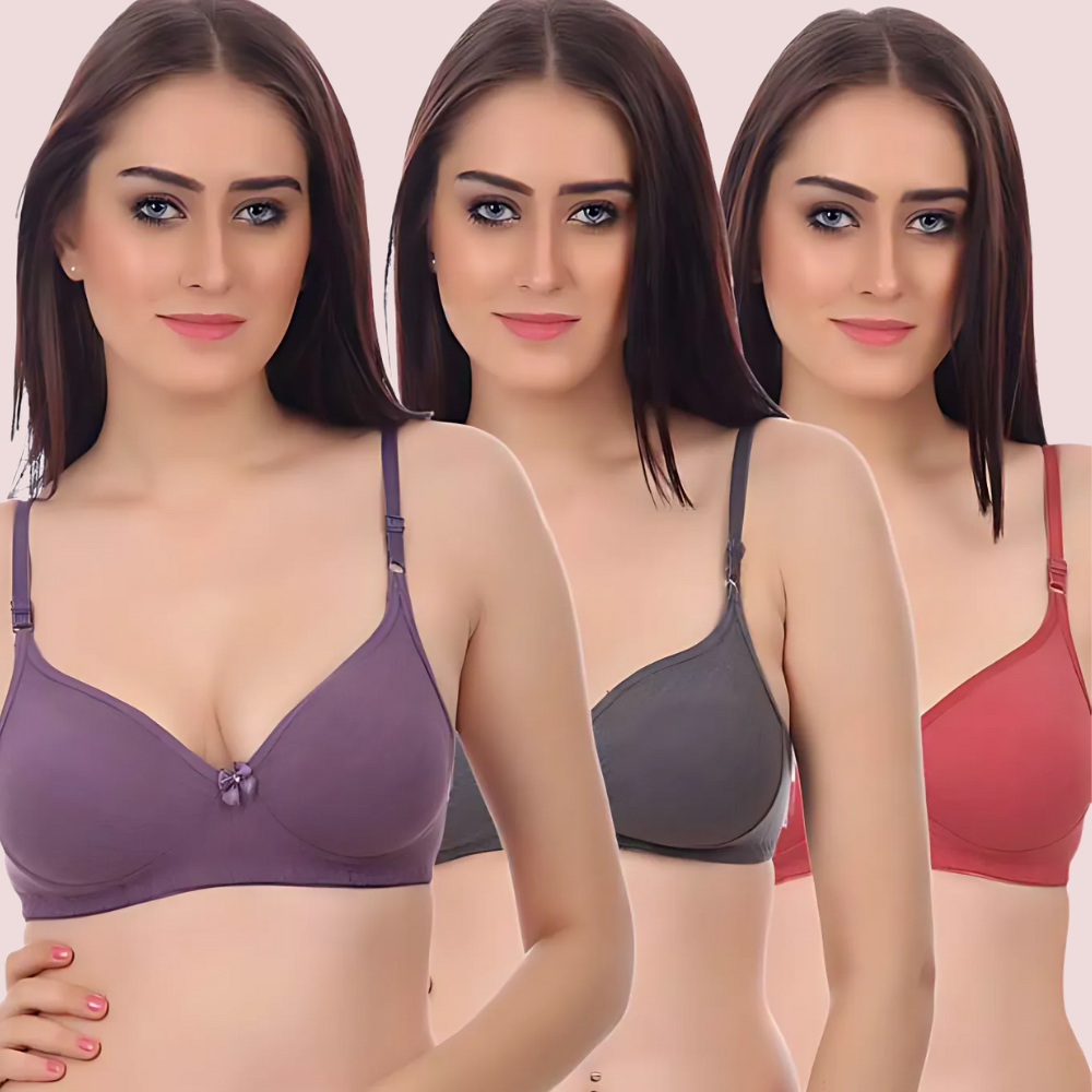 Three women wearing different colored bras on a plain background