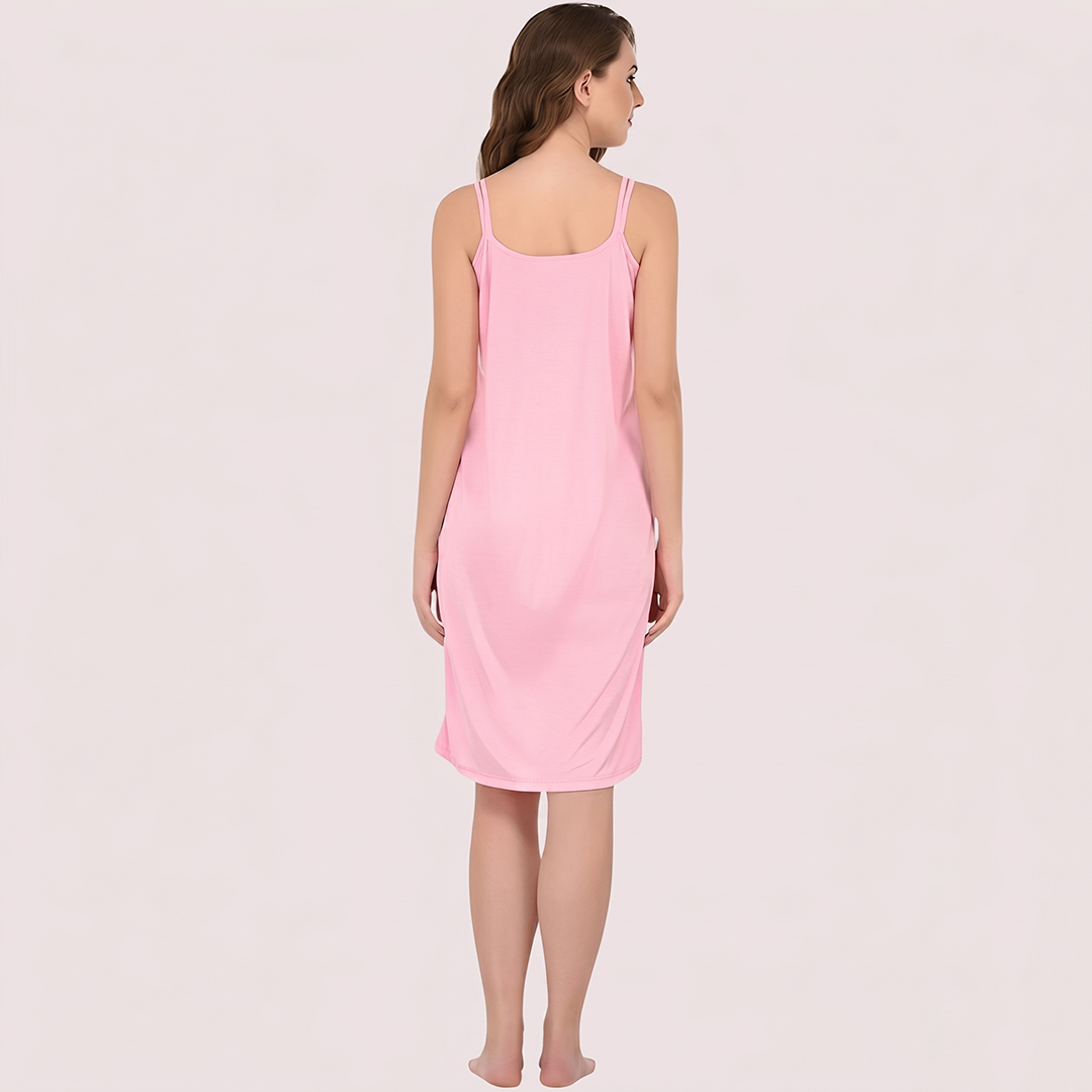Woman wearing a pink slip dress against a light pink background