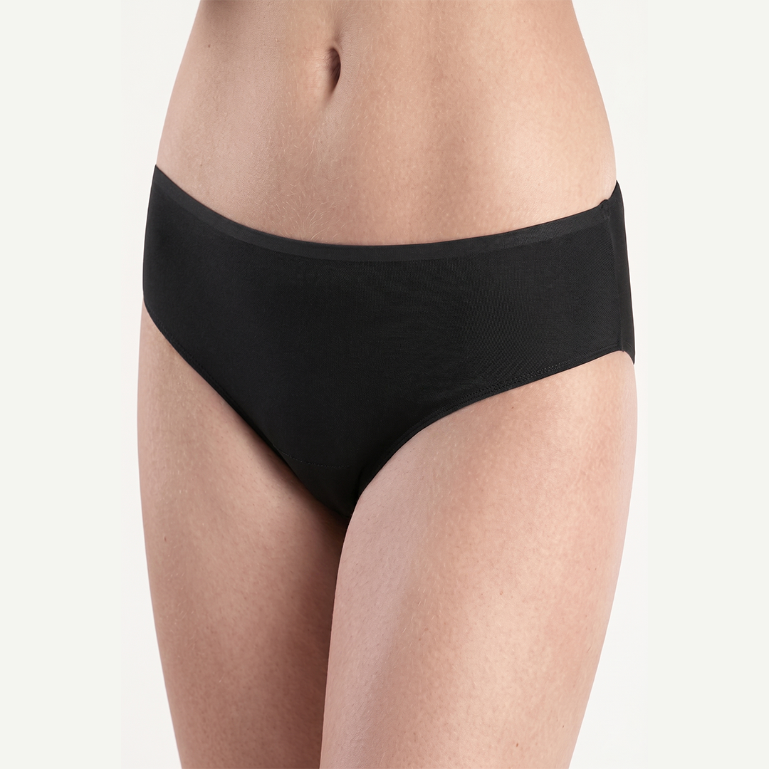 Black underwear worn by a person on a light gray background