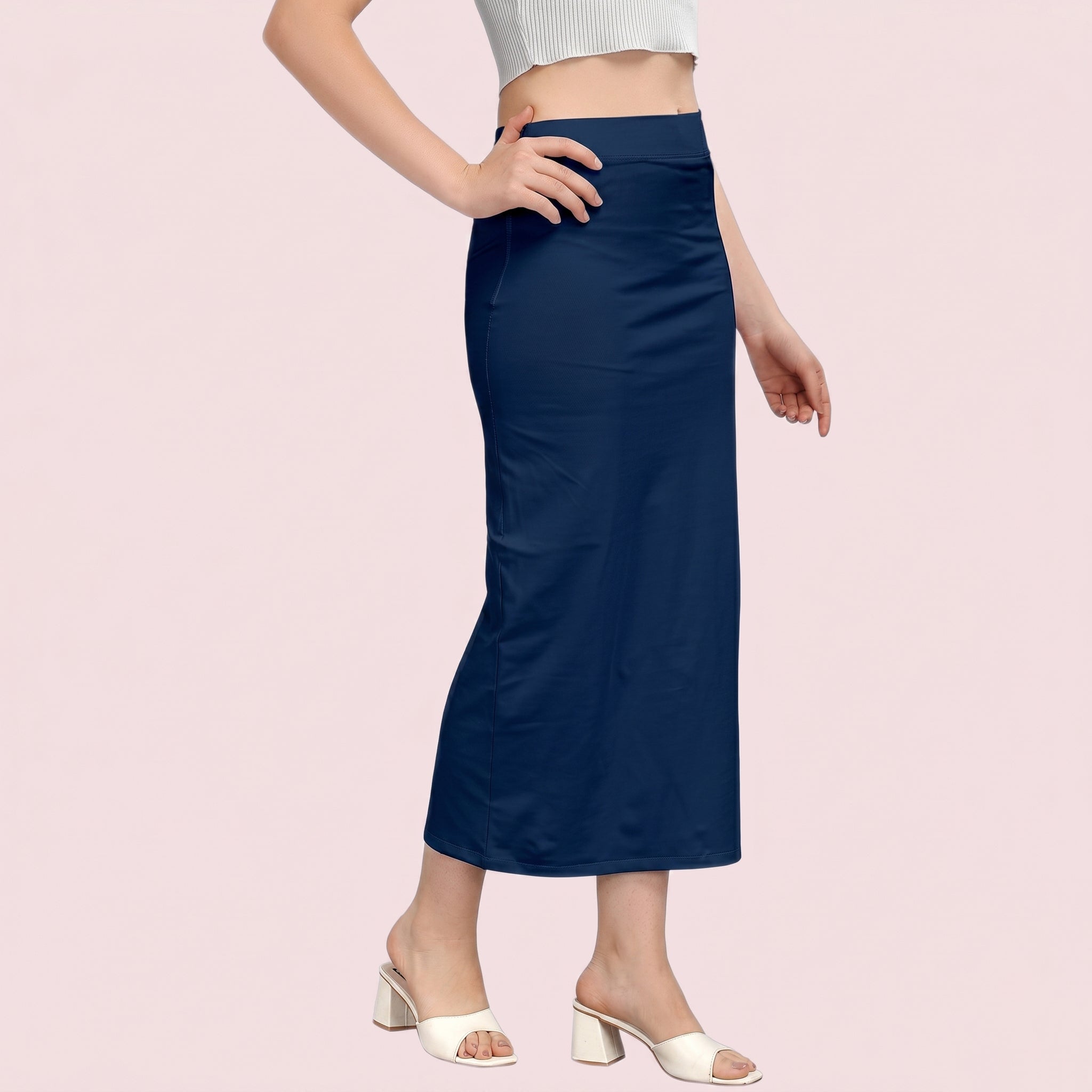 Person wearing a navy blue skirt on a light pink background