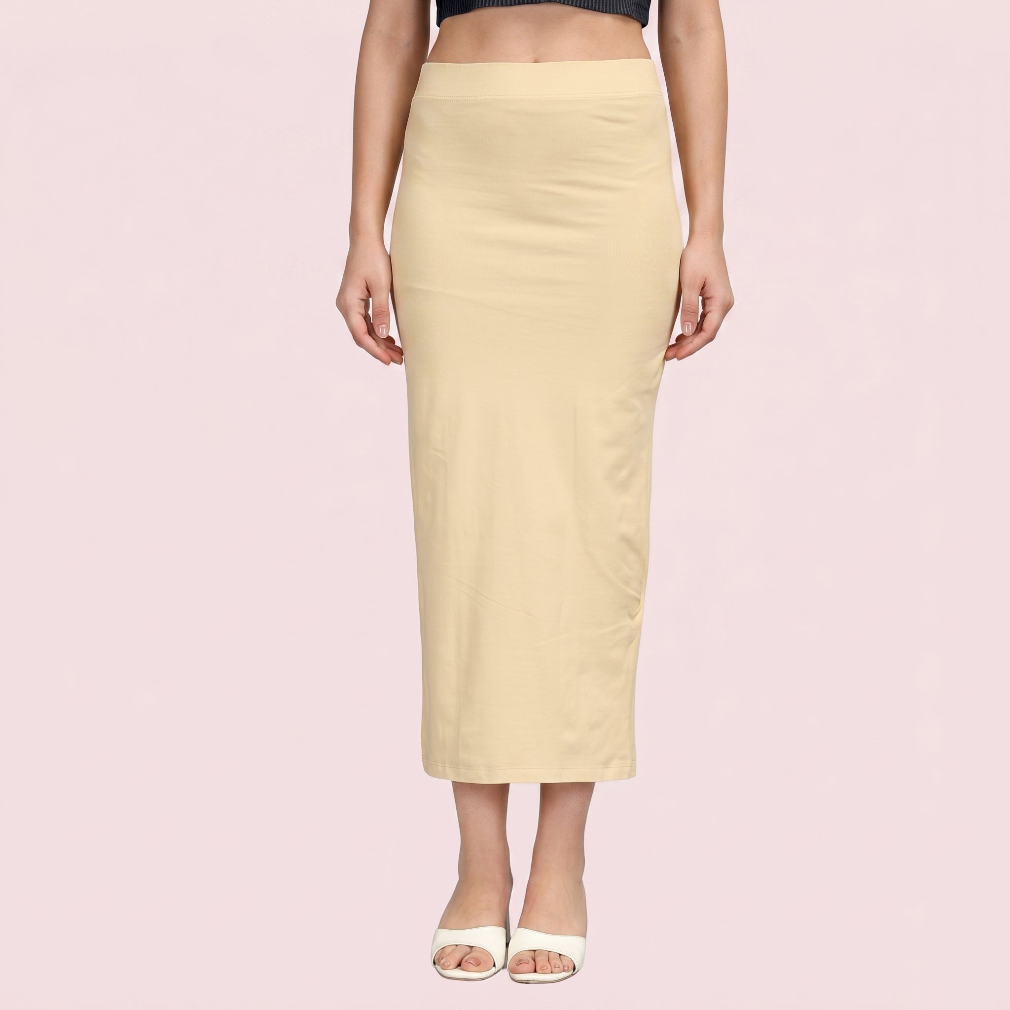 Beige pencil skirt worn by a person on a pink background