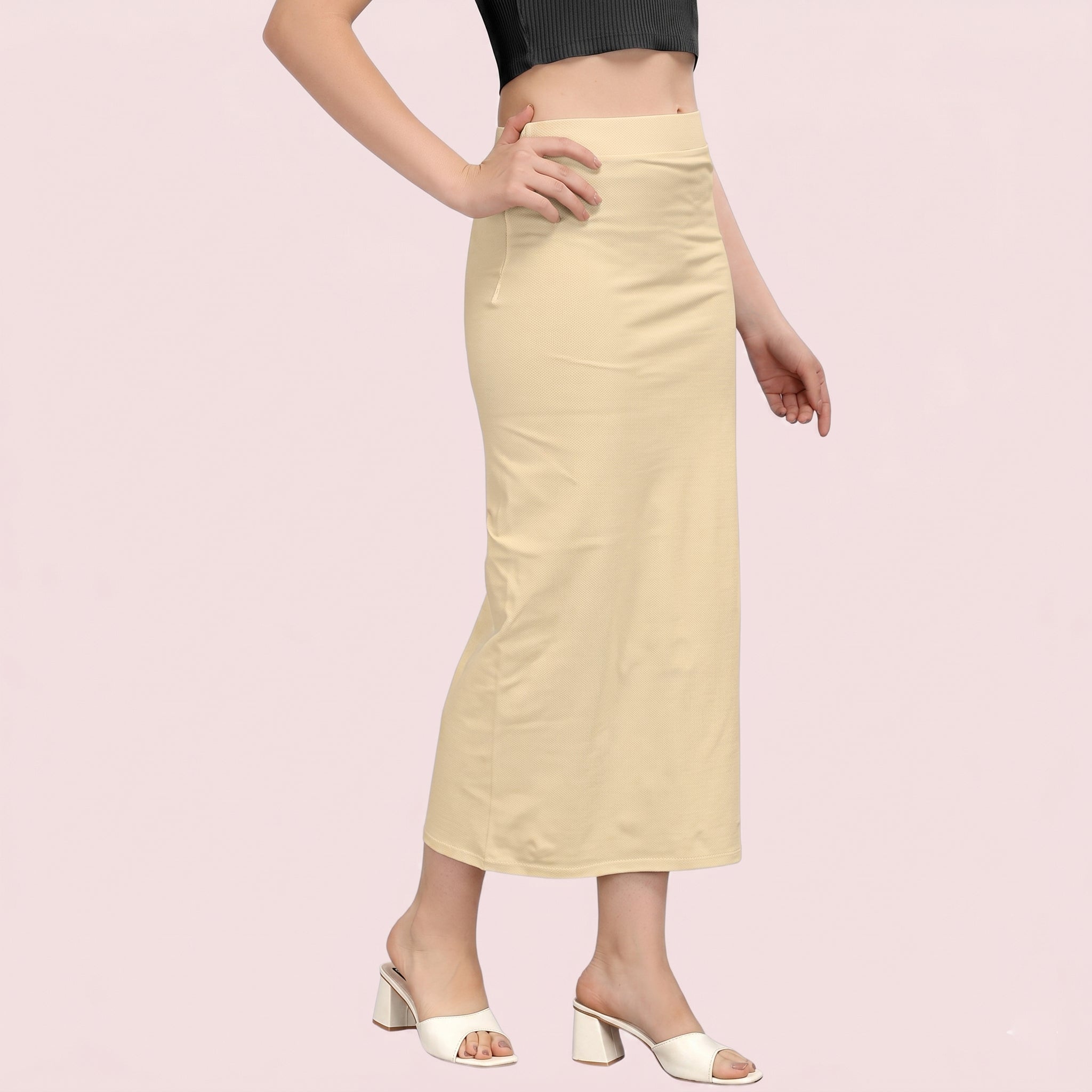 Beige skirt worn by a person on a pink background