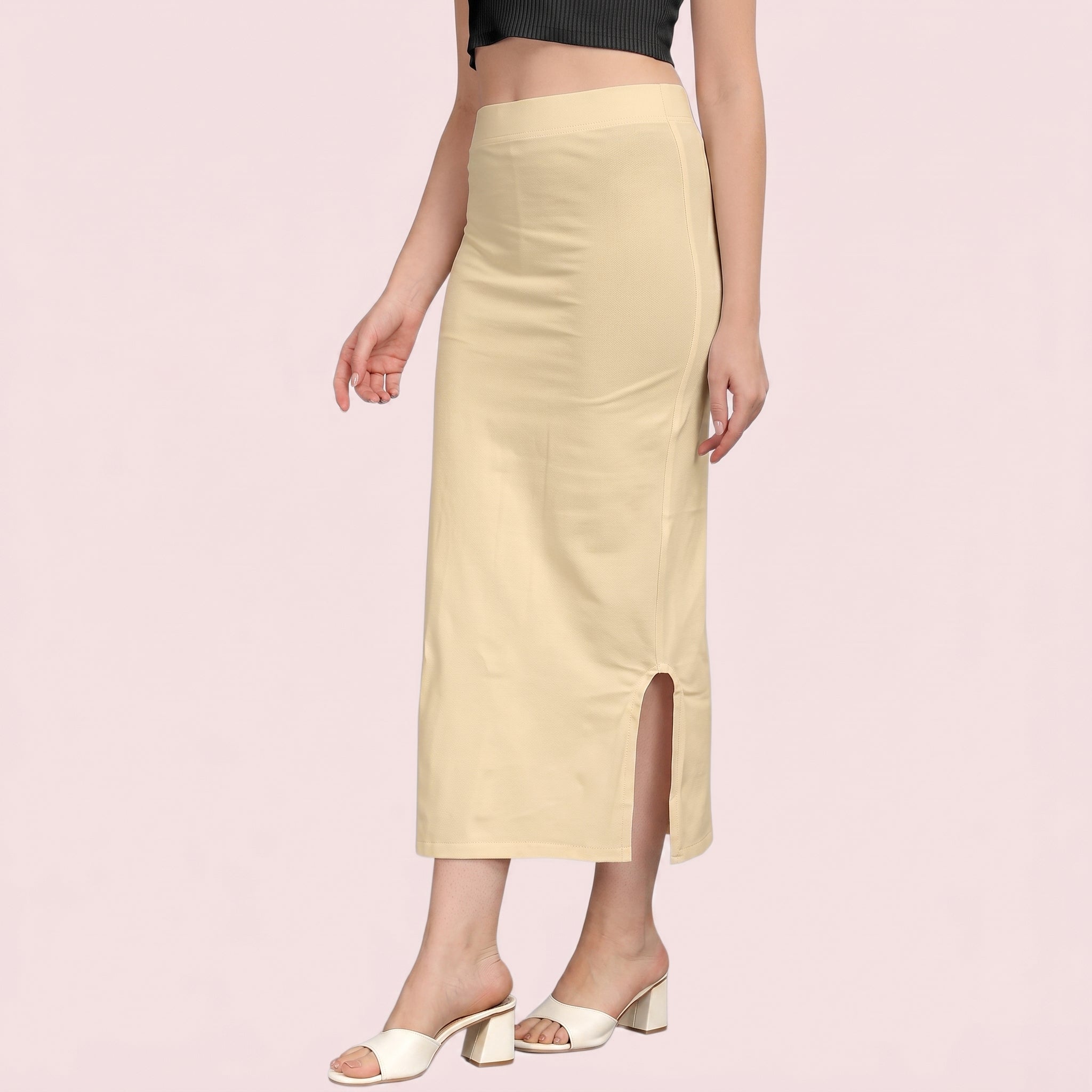 Beige skirt worn by a person on a pink background