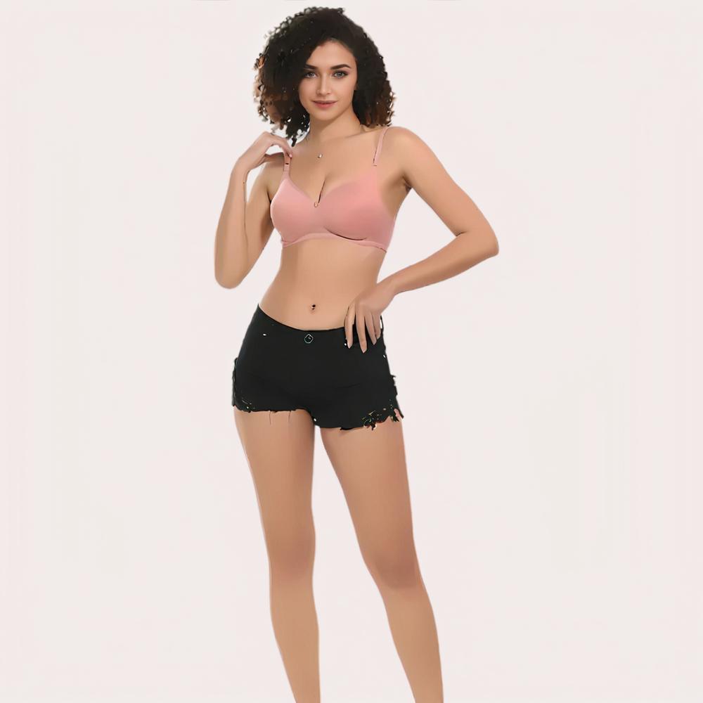 Woman wearing a pink bra and black shorts on a plain background