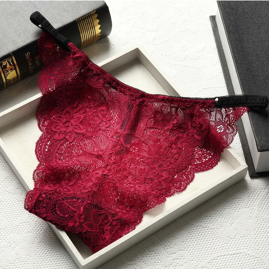 Red lace lingerie set on a white box with books in the background
