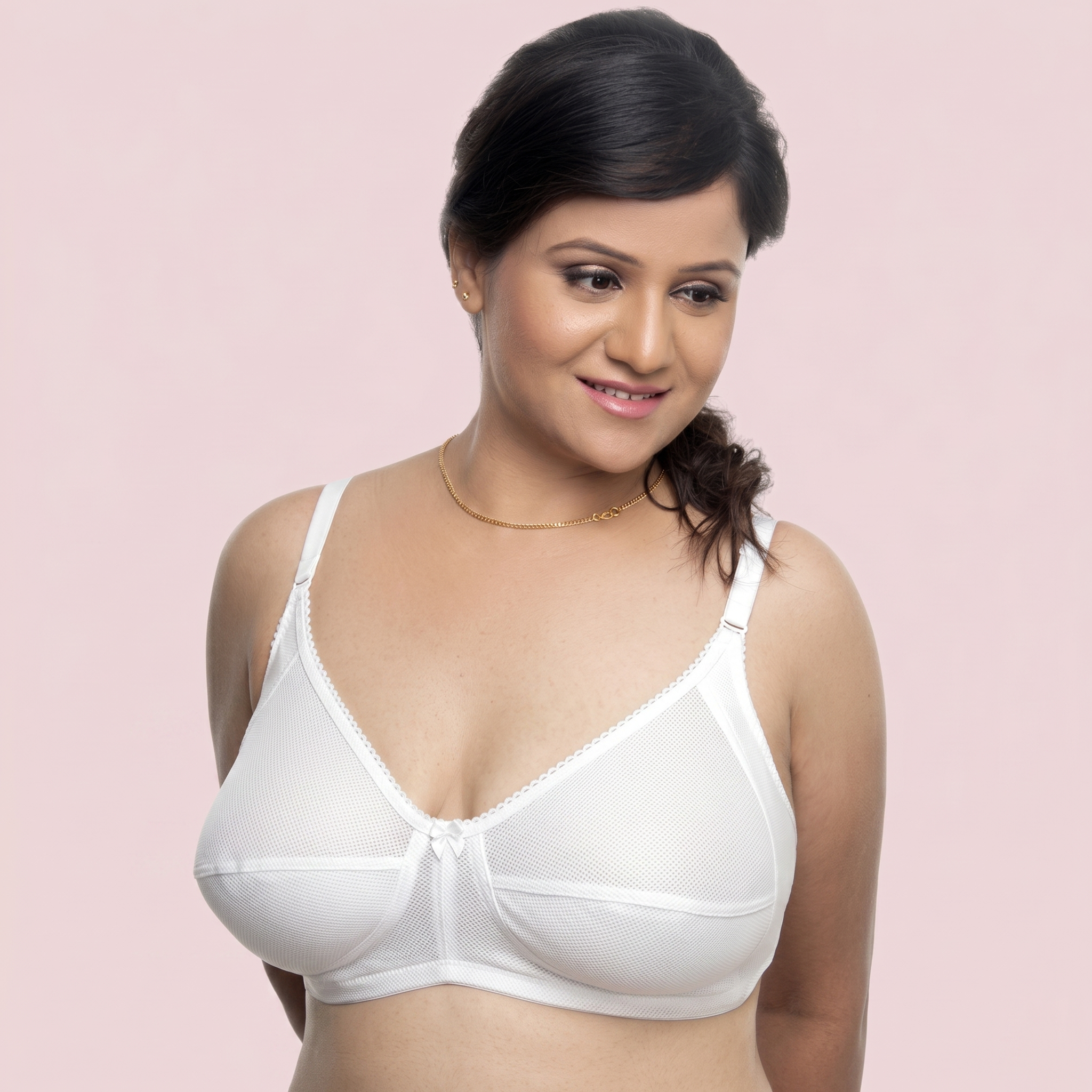 Woman wearing a white bra against a pink background