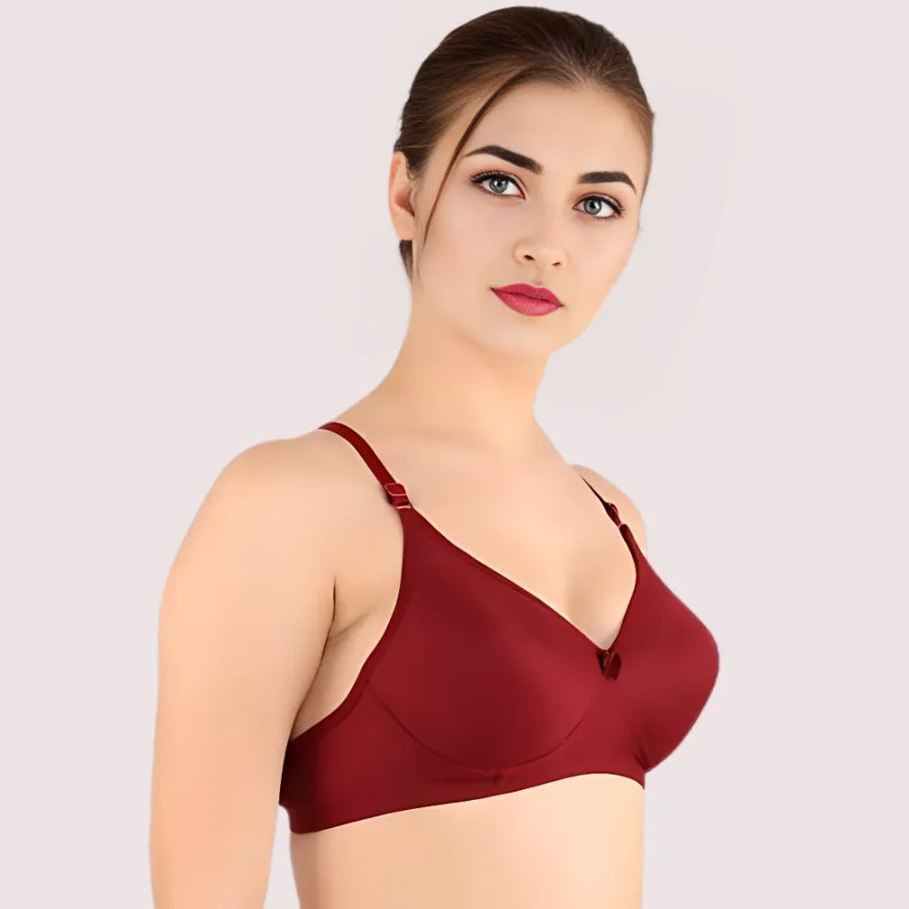 Woman wearing a maroon bralette against a light background