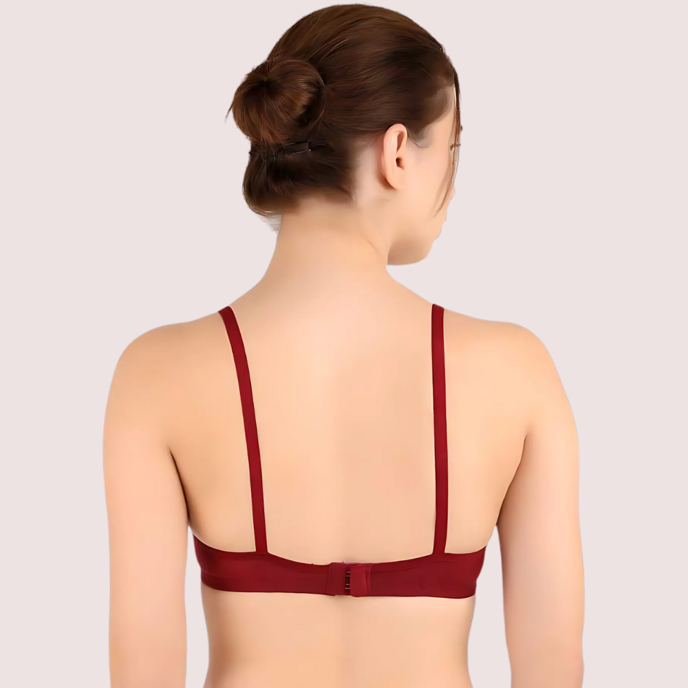 Woman wearing a red bralette on a plain background