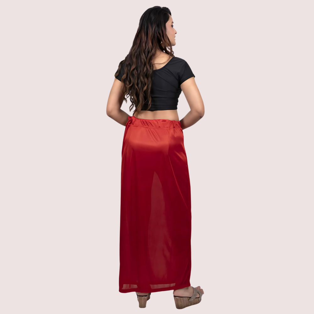 Woman wearing a black top and red skirt on a beige background