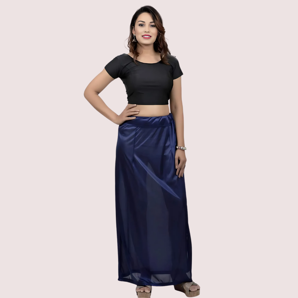 Woman wearing a black top and navy blue skirt on a light pink background