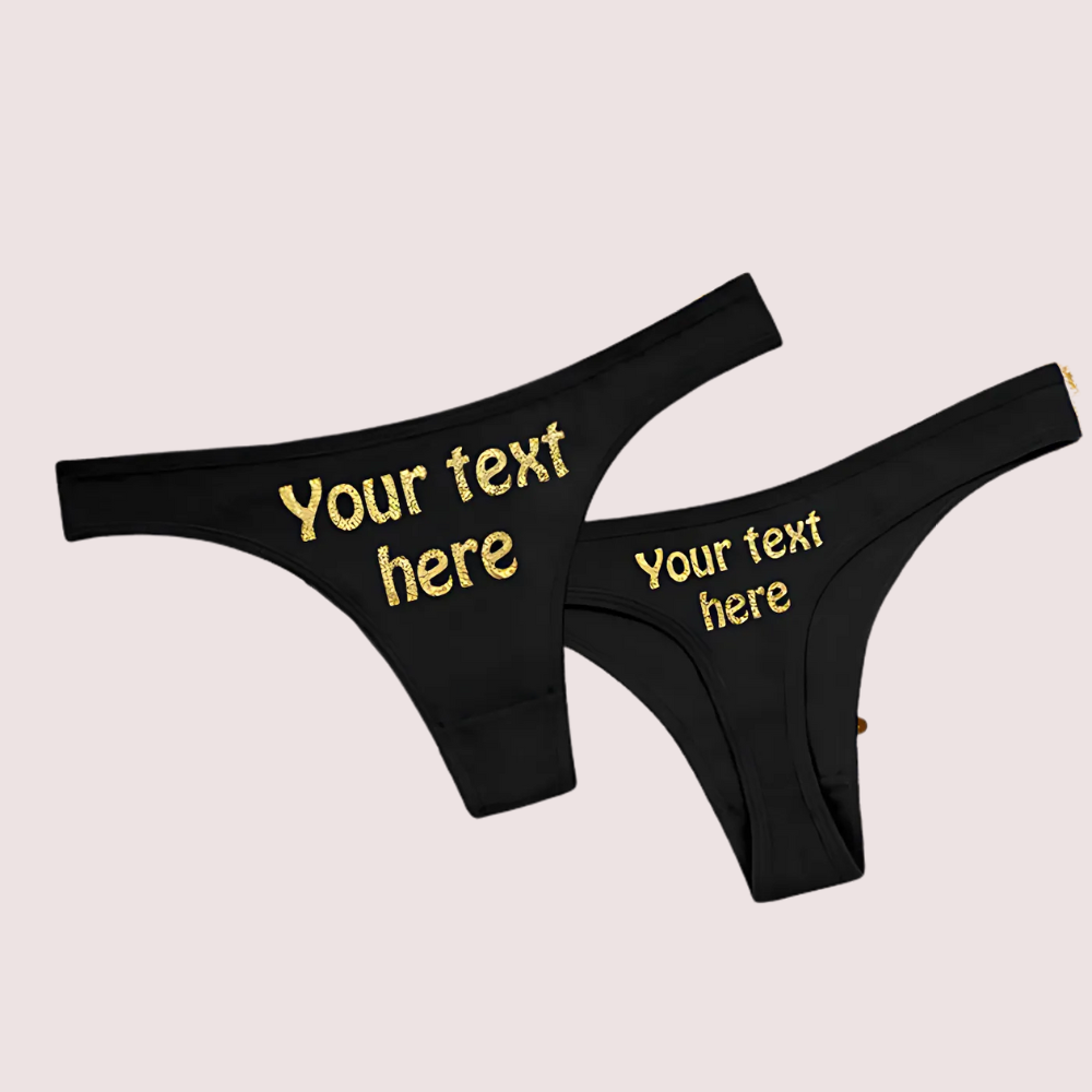 Black thongs with 'Your text here' printed in gold on a beige background